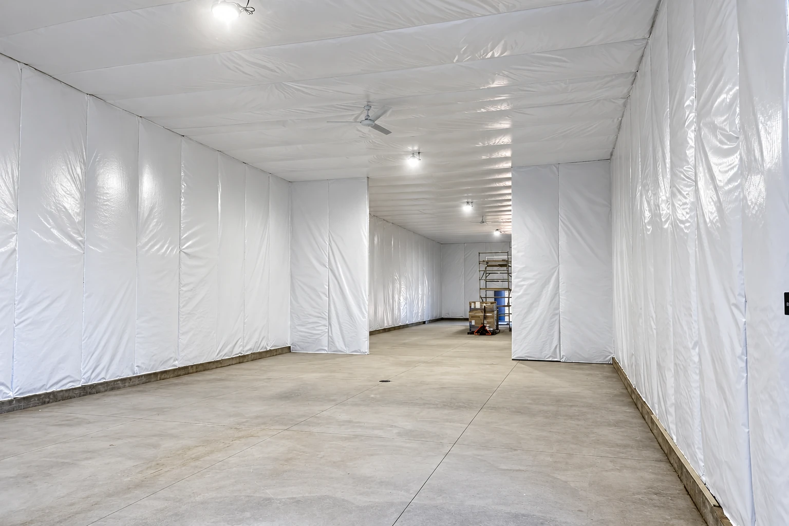 A large commercial interior has white insulation panels covering its walls and ceiling.